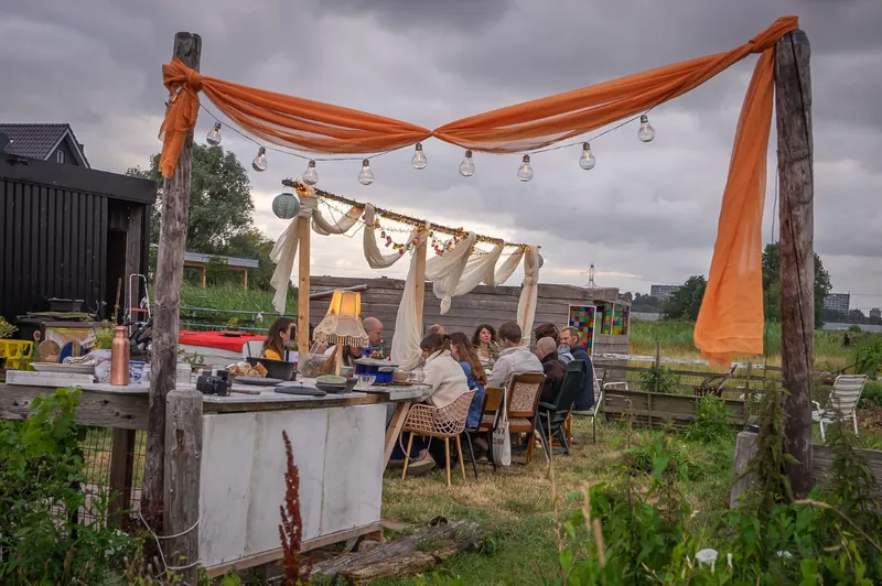Orange silk swag and festoon bulbs framing the dinner table beyond