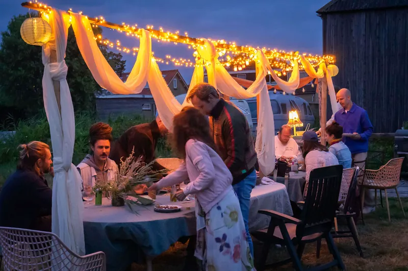 Dinner under lit drapes at blue hour, plates being passed