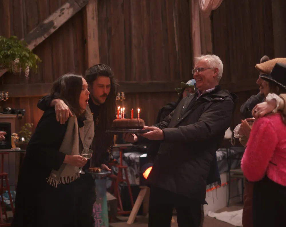 Birthday cake with candles carried through the barn