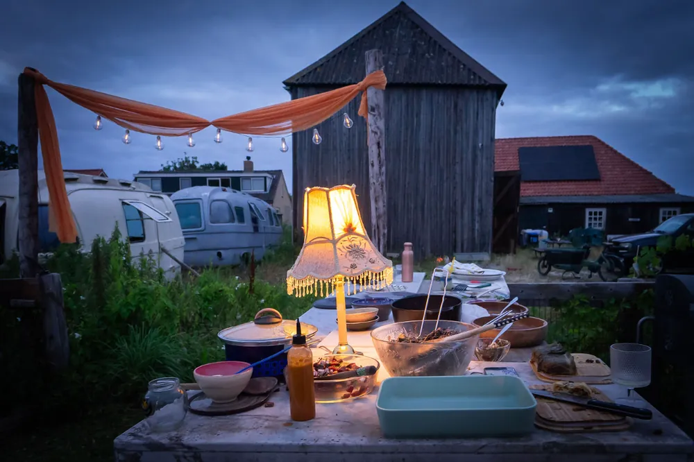 Lamp-lit buffet at dusk with the old wooden barn behind