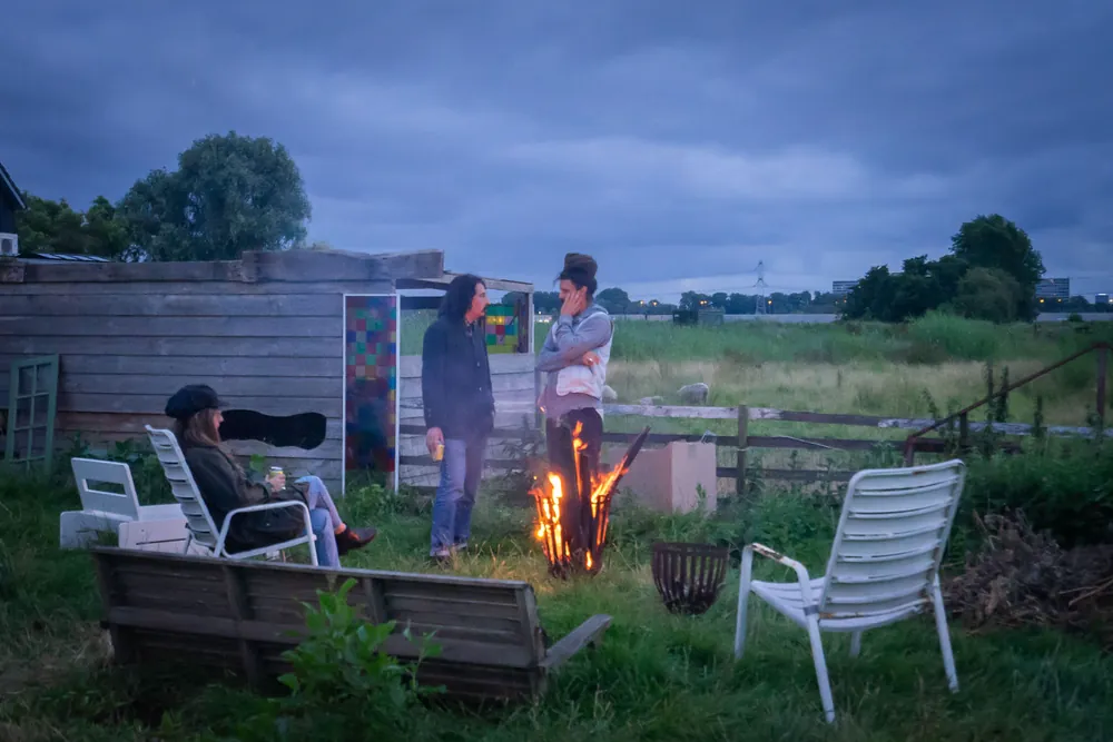 Fire pit with garden chairs on the meadow edge at dusk