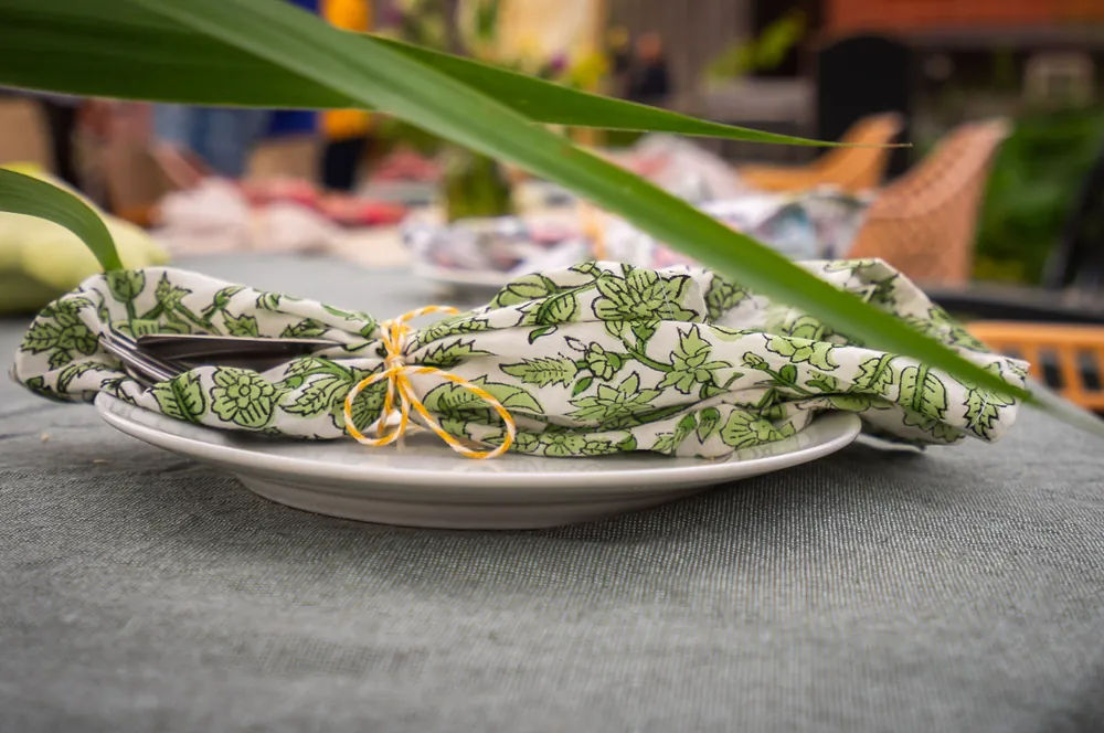 Leaf-print napkin tied with gold twine on a plate